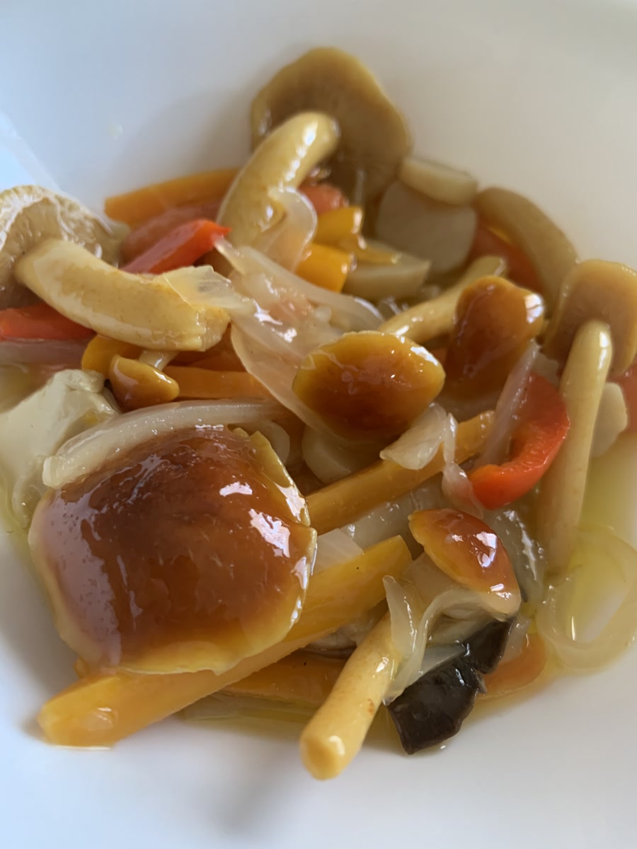 Pickled chestnut mushrooms with onion and peppers in a white bowl